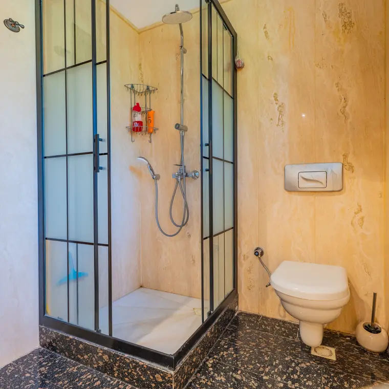 Siyah çerçeveli cam duşakabinli banyo